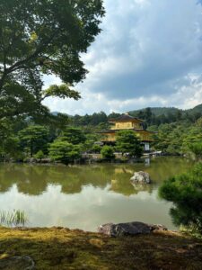 Calm lakeside view of a golden temple reflecting in still water