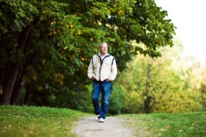 Older man walking calmly on a path, representing recovery from kinesiophobia and fear of movement
