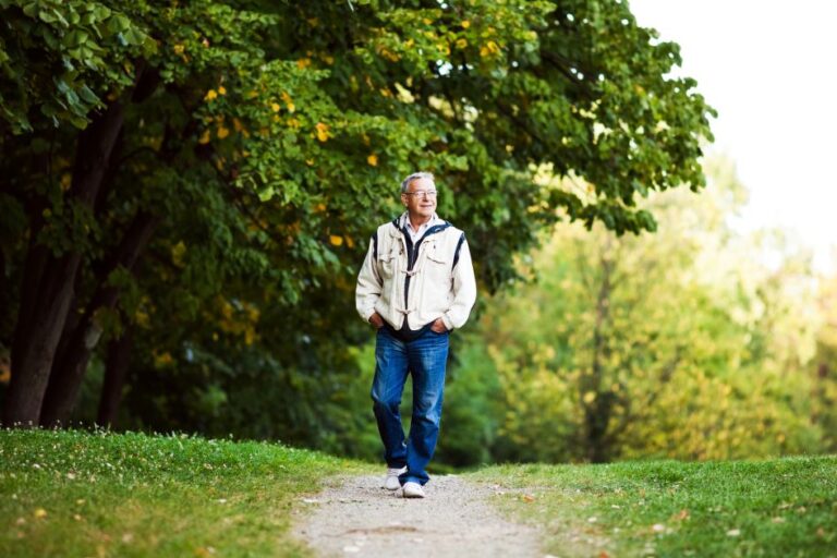 Older man walking calmly on a path, representing recovery from kinesiophobia and fear of movement